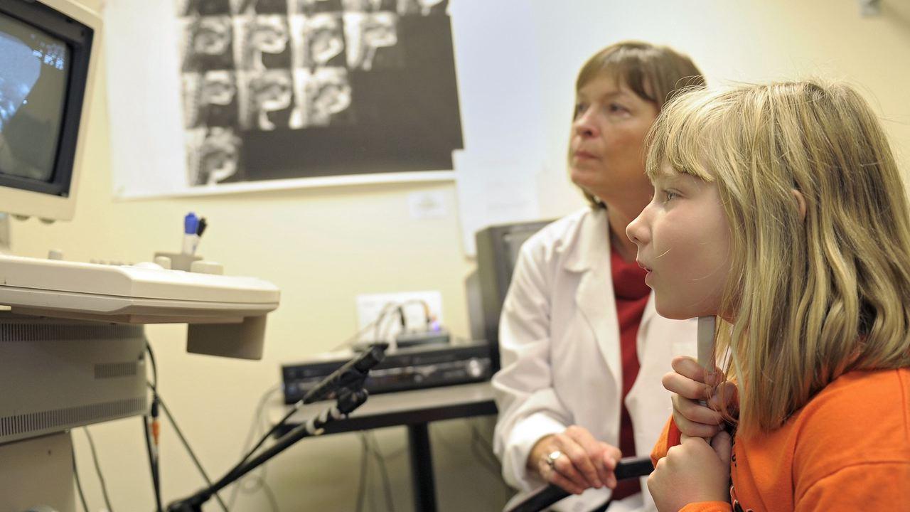 UC researcher in lab with child