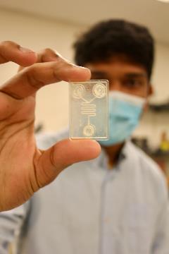 Remote diagnostics lab University of Cincinnati graduate student Isteaque Ahmed holds up a lab on chip in the remote diagnostics lab at UC.